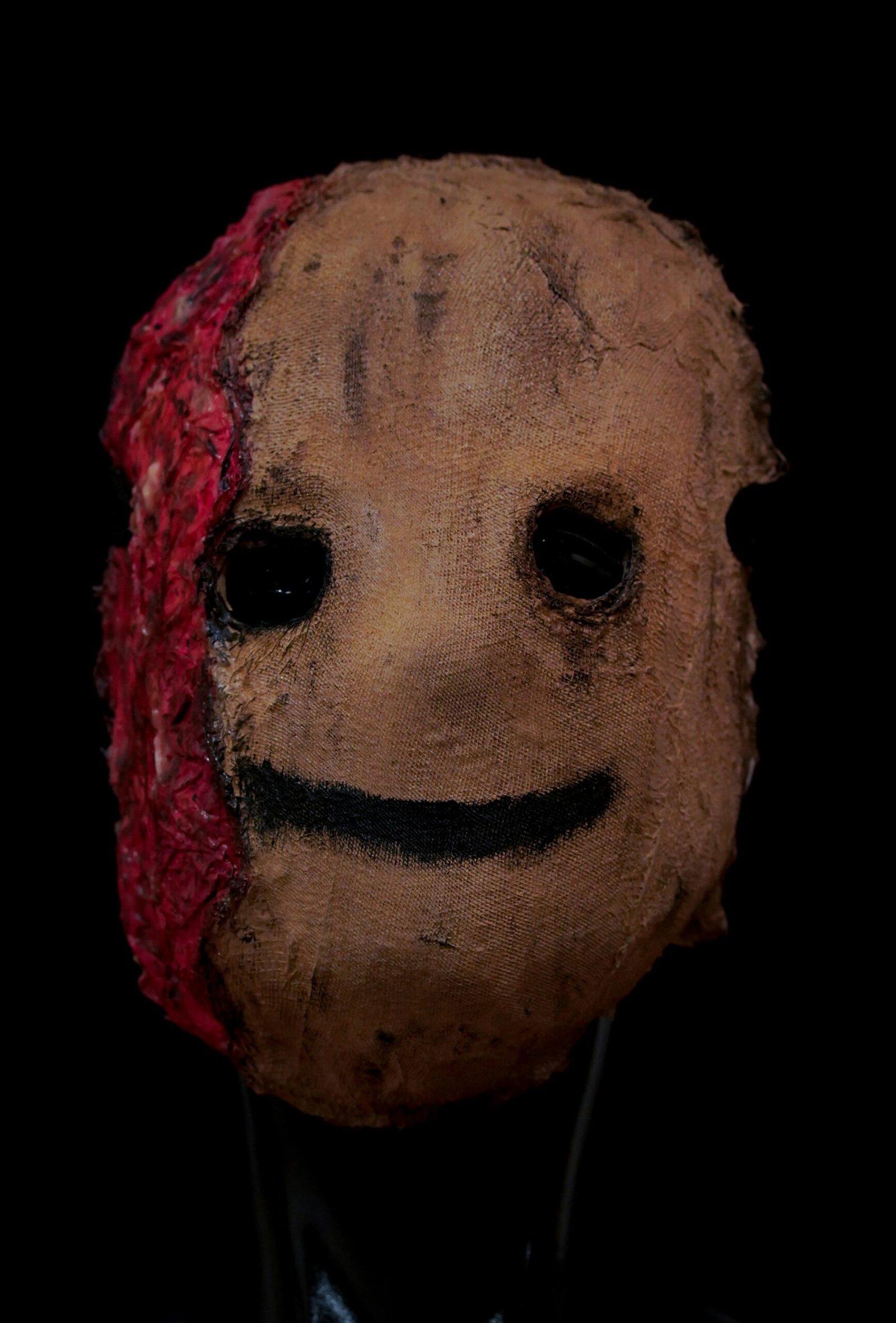 A creepy mask with a red bandanna around it's head